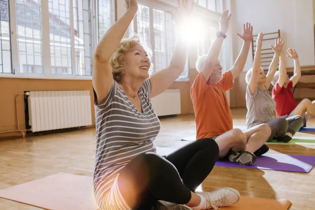 Group of seniors doing yoga in a gym