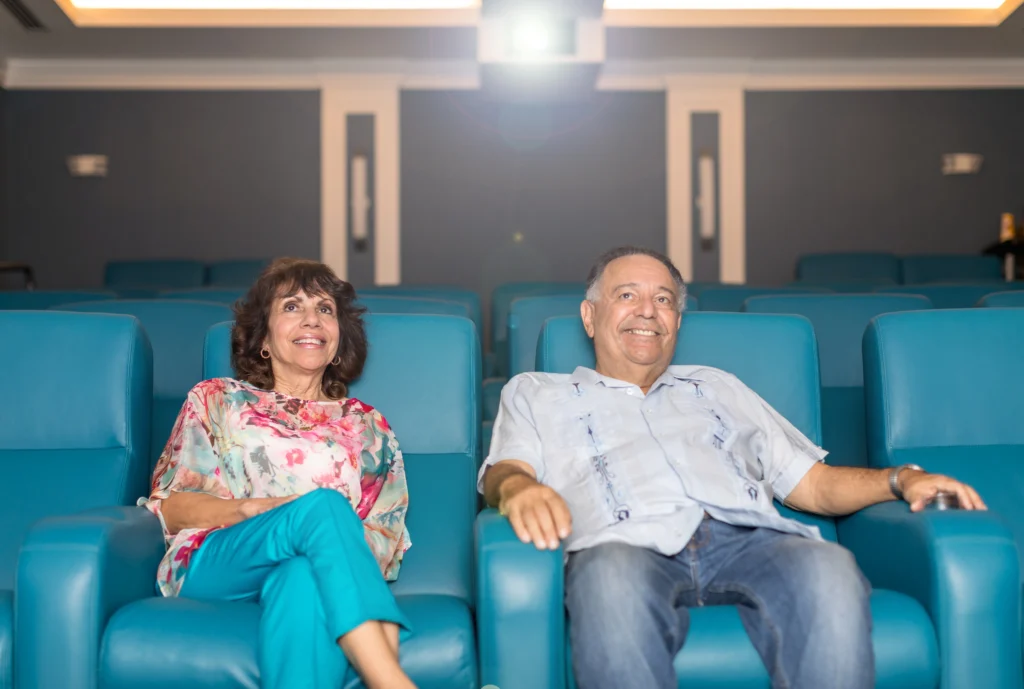 seniors in a movie theater, enjoying the retirement amenities at Windsor at Celebration in Florida.