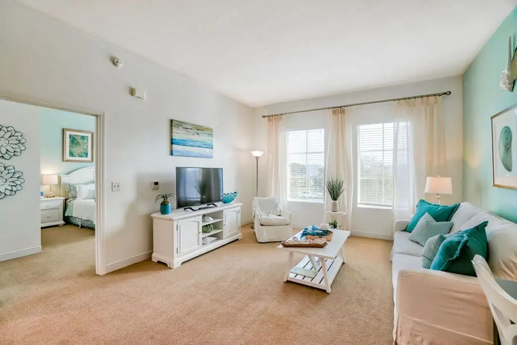 An image of a senior apartment layout featuring a tv, modern furniture with vibrant colors at a Windsor at Celebration, a independent living community.
