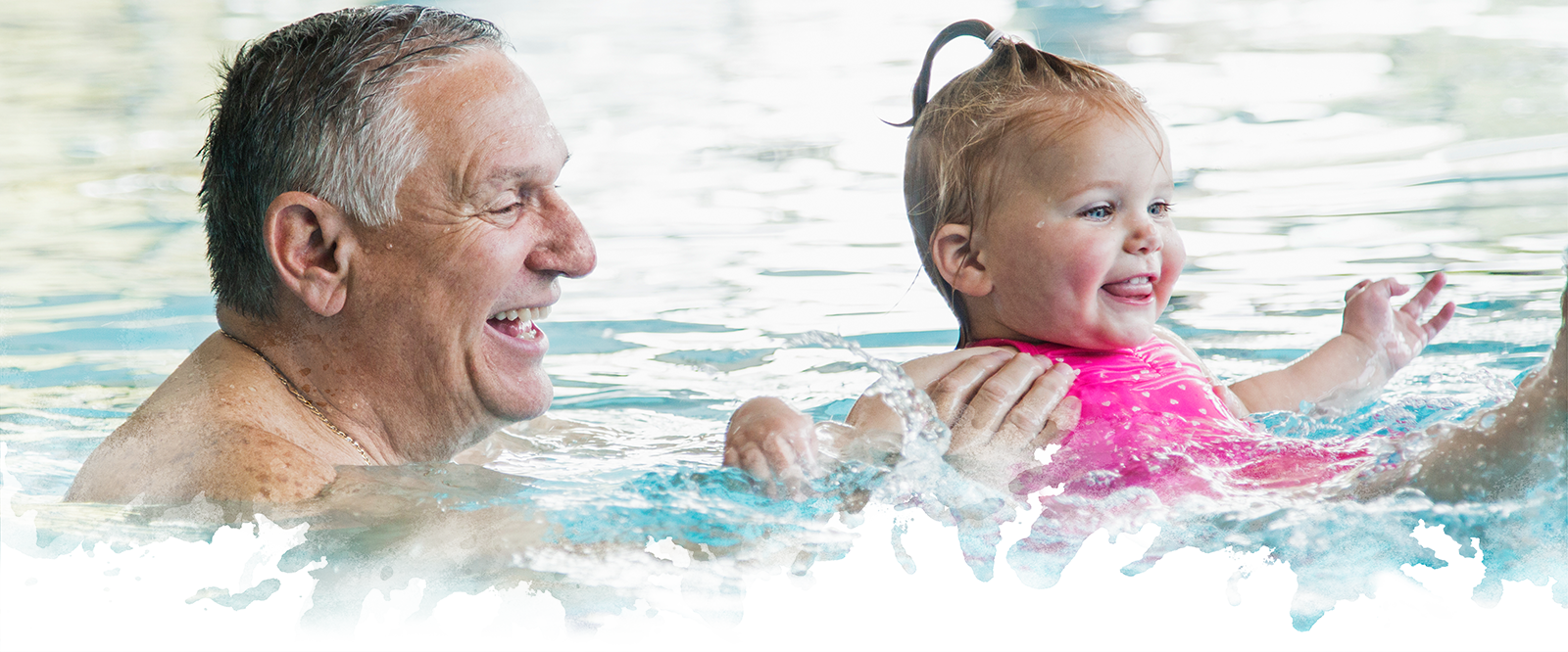 Grandfather and baby girl in swimming pool