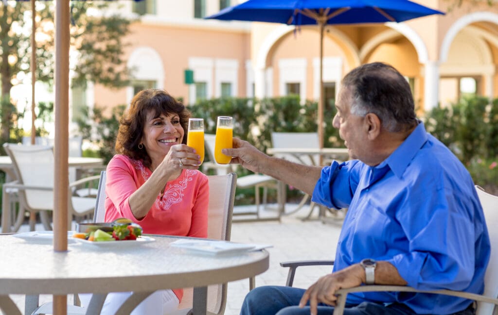 A senior couple dining outdoors at Windsor at Celebration a senior rental community in Celebration, FL.
