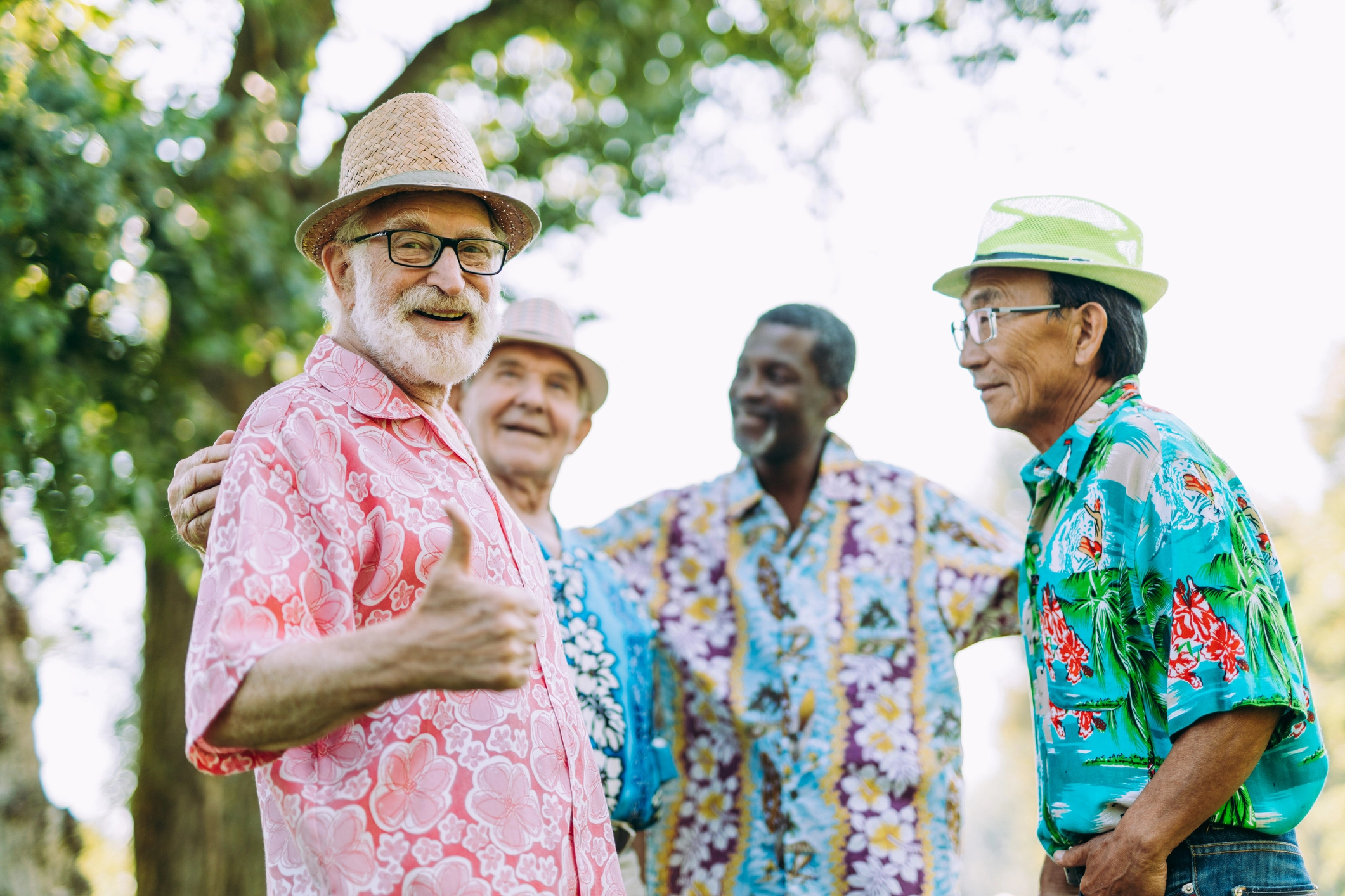 Senior men exploring senior companionship in retirement while hanging outside in Hawaiian shirts at Windsor at Celebration in Florida.