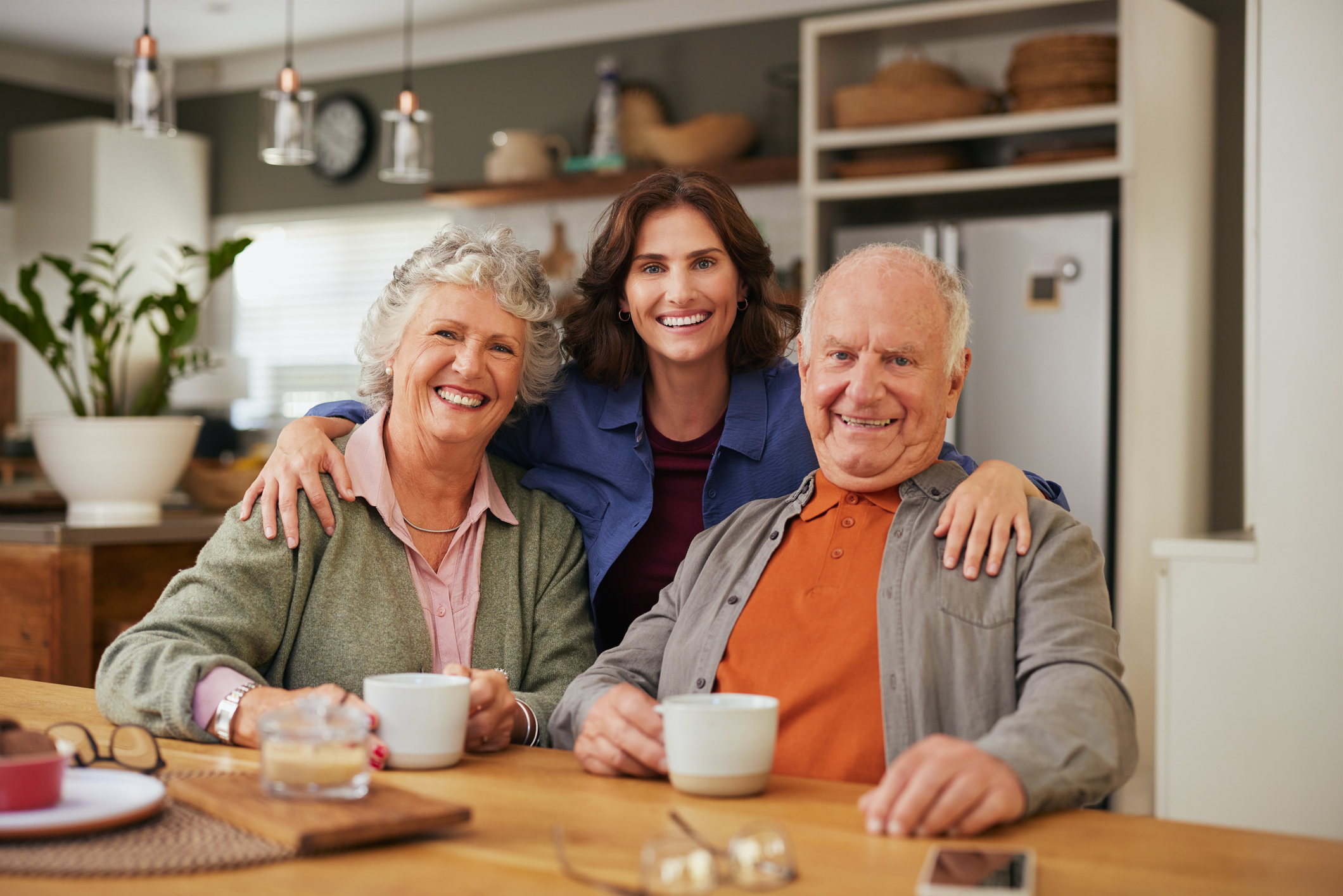 adult woman with senior parents at kitchen table